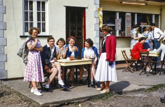 Group of young people sitting in front of a café, 1950 1955, England, UK