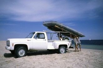 1977 GMC Sierra Super Custom 496 pickup truck vehicle two men unloading a rubber dinghy on the