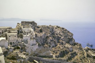 View of traditional village buildings with ship arriving, Oia, Santorini, Cyclades islands, Greece,