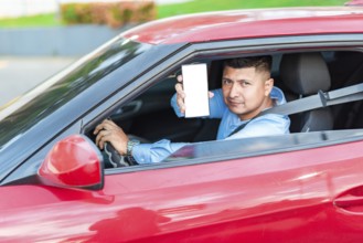 Handsome driver showing cell phone screen outdoors. Smiling male driver showing cell phone screen