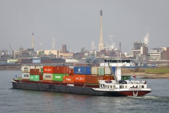 Krefeld, North Rhine-Westphalia, Germany - Cargo ship sails on the Rhine past the chemical plant