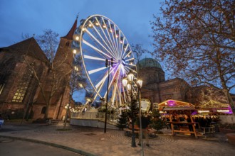 Ferris wheel at the winter village, Christmas market at dusk, St James' Church on the left, St