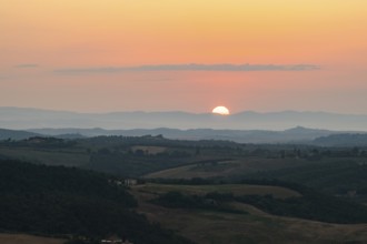 View from Montepulciano into a typical Tuscan landscape in Val d'Orcia with hills, trees, fields,