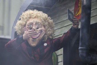 Person masked as Thomas Gottschalk at the carnival parade of the Wey guild on Rose Monday,