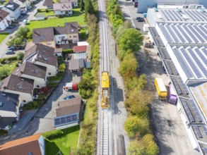 Aerial view of a residential area with adjacent railway tracks and industrial buildings in the