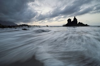 Dramatic clouds with rock formation at rising tide at the beach of Playa de Benijo, Tenerife,