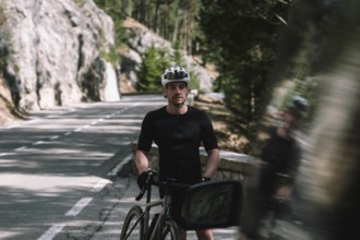 Road bike rider in spring in the Allgäu against the picturesque backdrop of the Alps, Bavaria,