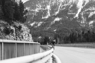 Road bike rider in spring in the Allgäu against the picturesque backdrop of the Alps, Bavaria,