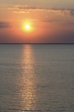 Sunset over the calm North Sea, the outline of the island of Juist on the horizon, Norddeich, Lower