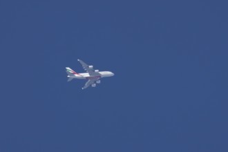 Airbus A380 jet aircraft of Emirates airlines flying in a blue sky England, United Kingdom, Europe