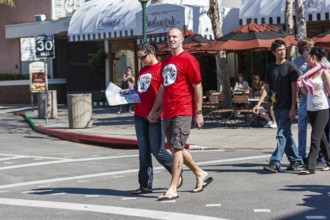 Young couple wearing Thing 1 and Thing 2 t-shirts walking on street in Universal Studios, Orlando,