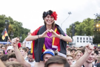 Celinda forms a heart with her hands in the fan zone at the Brandenburg Tor during the round of 16