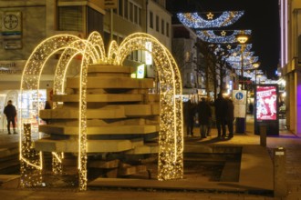 Illuminated fountain and Christmas decoration above the pedestrian zone, night shot, Paderborn,