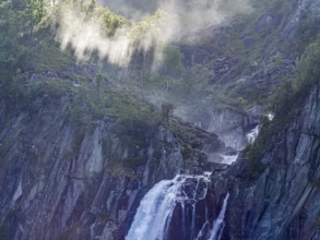 Sunbeams over waterfall Hivjufossen near Hovet, north of city Geilo, Norway, Europe