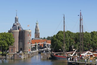 Town view of Enkhuizen with harbour entrance and historic old town with defence tower of