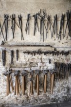 Historic forge, tools hanging on a wall, museum, Salem Castle, former imperial abbey, former