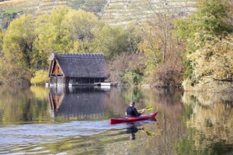 Boathouse with paddle boat at Max-Eyth-See in Stuttgart in autumn. The lake is an artificial lake