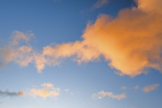 Orange spring clouds adorn the blue morning sky at sunrise