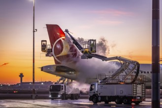 Frost at the airport, a Turkish Airlines aircraft is de-iced in front of sunrise. Airbus A321-231,