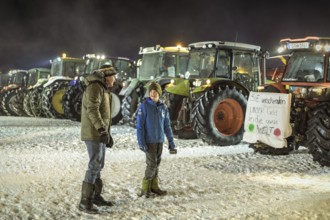 Tractors during a rally as part of the farmers' protests on the snow-covered Kirchbichl,