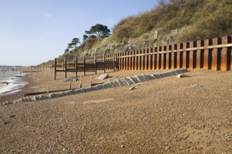 Rusty steel piling sea wall defences and shingle beach near Bawdsey Quay, Suffolk, England, United