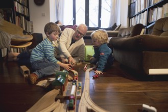 Playing children, two and four years old and their grandfather, in the family, Bonn, 24.12.2023. In