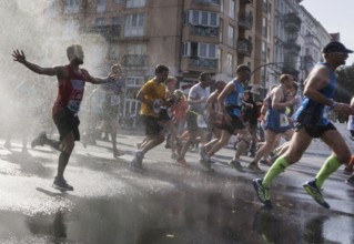 The participants of the Berlin Marathon are cooled down with a water shower in the Schöneberg