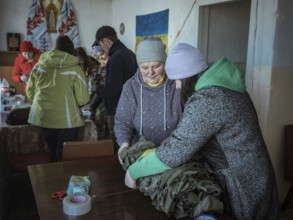 Women packing camouflage nets during a birthday party in the frontline village of Shevchenkove,