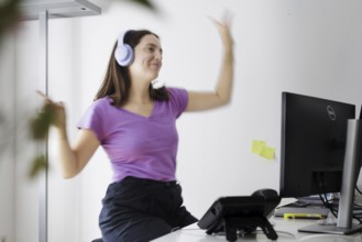 A woman dances at her workplace in Berlin, 08/08/2024