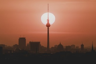 The sunrise emerges behind the city skyline with the television tower in Berlin, 04/09/2024