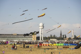 Flying kite in the shape of Batman in front of the tower at the kite festival on Tempelhofer Feld