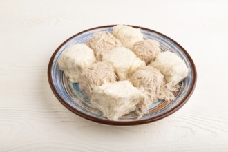 Traditional arabic sweets pishmanie on white wooden background. side view, close up