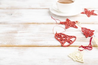 Christmas or New Year composition. Decorations, red stars, bells, on a white wooden background.