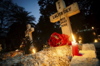 People from Christian community light candles and offer prayers on the grave of their relative