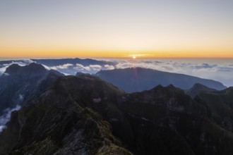 Aerial drone view of mountains over clouds near Pico Ruivo on sunset. Madeira island, Portugal,