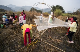 Villagers participate in a community fishing event on the occasion of the Bhogali Bihu festival at