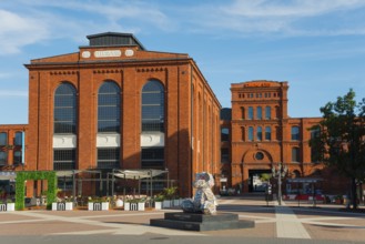 Square with sculpture and surrounding historic brick structures, Manufaktura, Lódz, Lodz, Lodz,