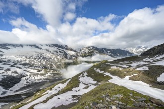 Mountain landscape with snow fields and high fog in the valley, summit Hoher Weißzint and