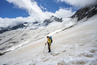 Mountaineer in a snowfield, descent from the summit of Schönbichler Horn, view of snow-covered and