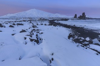 Rocks, lava field and surf at the coast, evening light, sun, snow, winter, Arnarstapi,