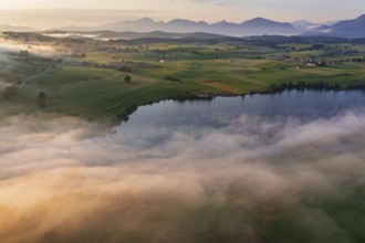 Aerial view of a lake in front of mountains in the morning light, fog, autumn, Riegsee, view of