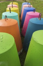 Two rows of fluorescent green, orange, blue, pink, turquoise and yellow painted bell shaped