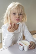 Portrait of blonde girl, 3 years old, having lunch in Ystad, Skåne County, Sweden, Scandinavia,