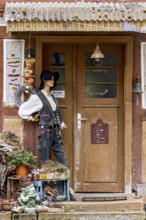 Old half-timbered house, entrance curiously decorated with mannequin in costume, carpenters' guild,