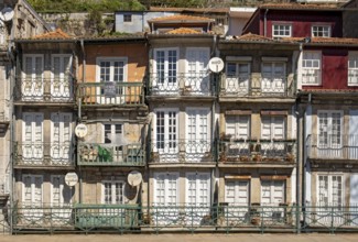 Front facades of narrow houses in the historic center near the Douro river in Porto, Portugal,