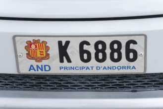 Nummernschild eines Autos aus Andorra mit Wappen und Schriftzug auf weißem Hintergrund, Fürstentum