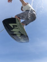 Young man jumping and flying with wakeboard, water sports and water skiing in the wakepark