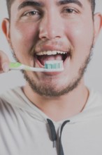 Smiling man brushing teeth isolated. Health and tooth brushing concept