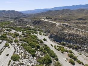 Dry landscape with hills and river valleys under a sunny sky, aerial view, Tabernas Desert,