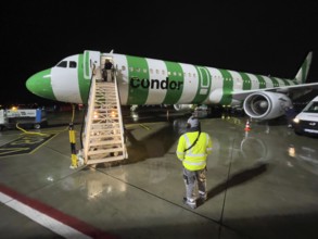 Night shot of Condor aircraft plane Airbus A321 standing landed in parking position on apron apron